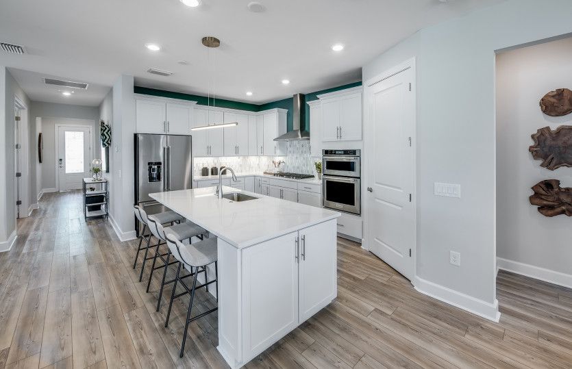 Large kitchen island with quartz countertops and white maple kitchen cabinets