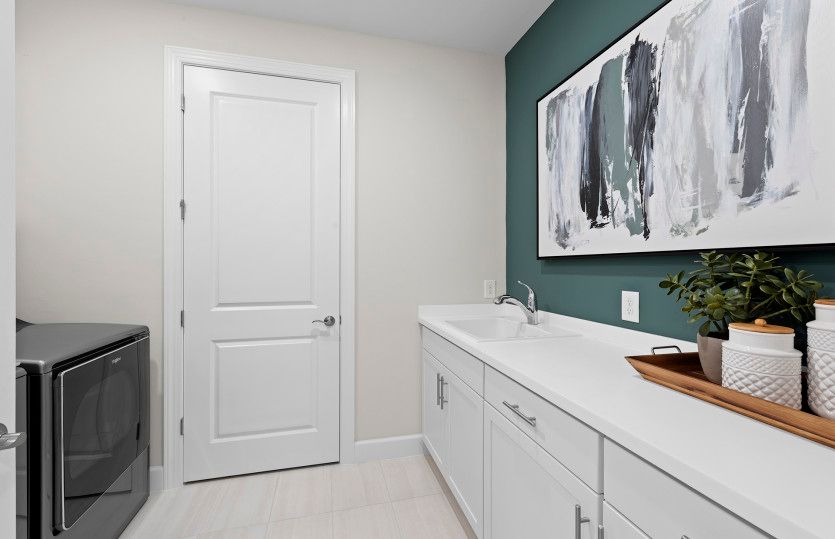 Spacious laundry room with extra storage space and utility sink
