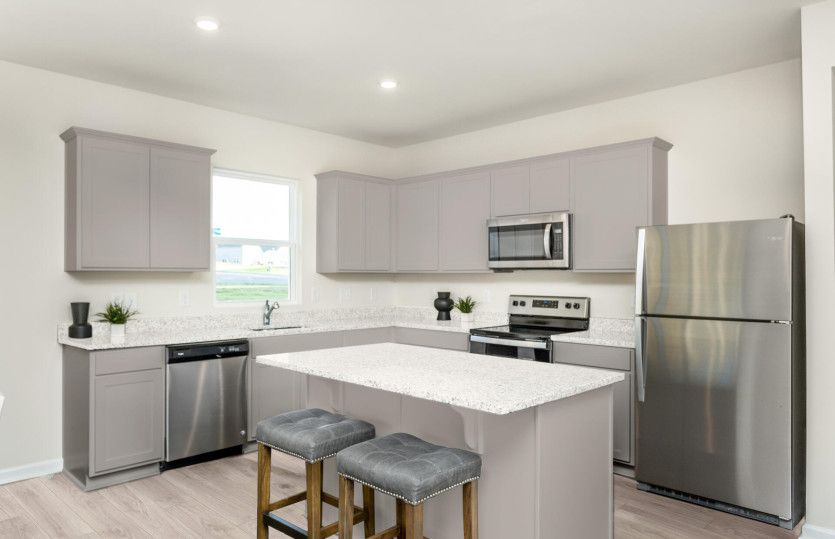 Kitchen with gray cabinets and quartz countertops.