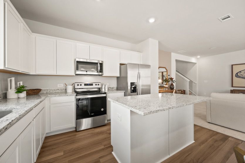 A spacious island with space to provide seating serves as a focal point for both meal preparation an