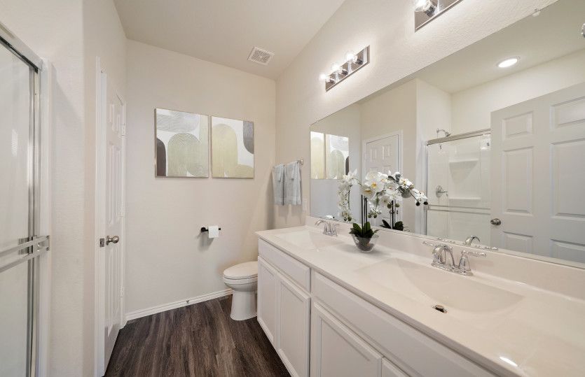 Modern owner's bath with dual vanities and a spacious shower