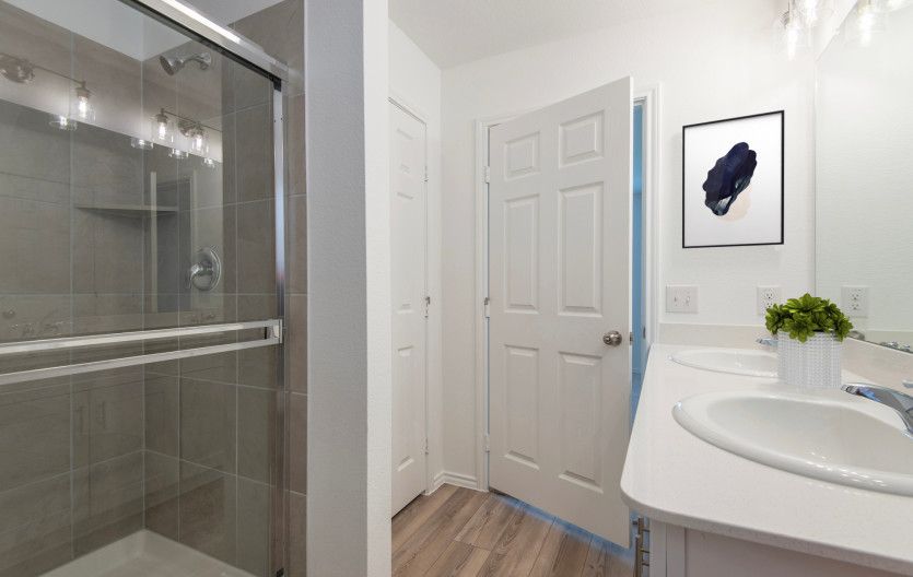 Modern owner's bath with dual vanities and a spacious shower