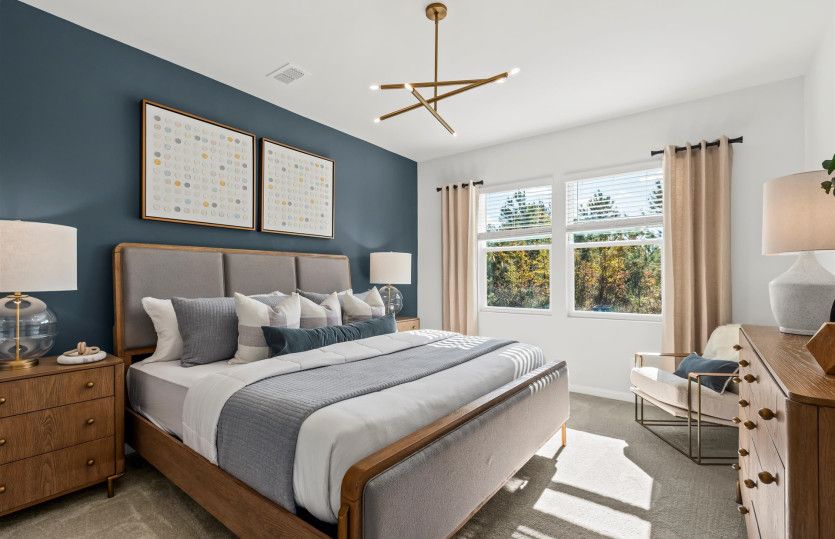 Step into the Owner’s Suite, a spacious and serene retreat with a beautiful chandelier.