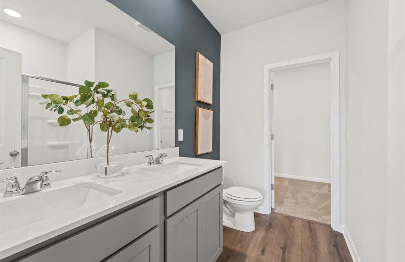 Featuring dual vanities for added convenience, the owner's bath offers a serene atmosphere.