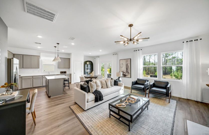 This versatile living space seamlessly integrates the living room, dining area, and kitchen, creatin