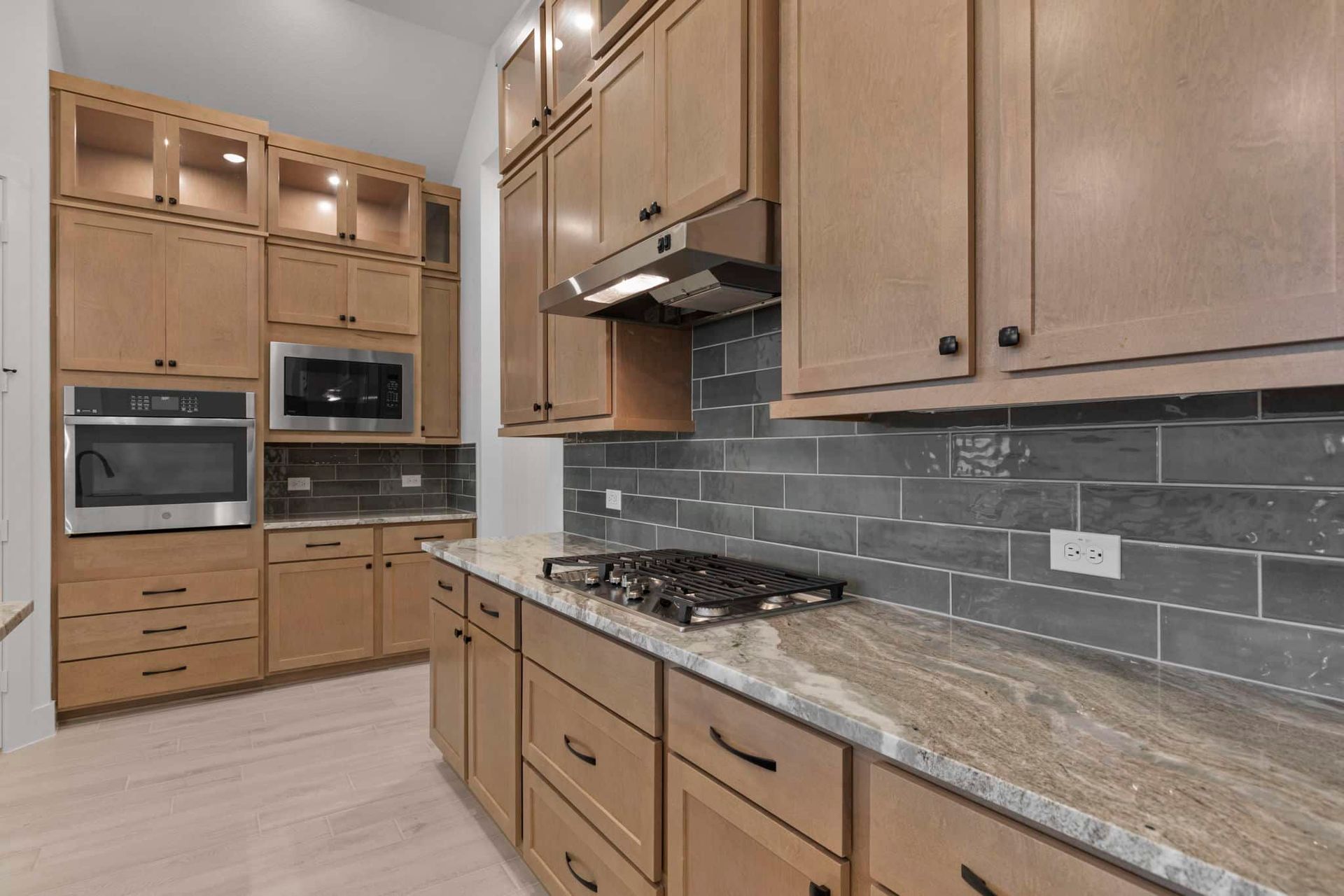 Kitchen with many wood cabinets and tile backsplash