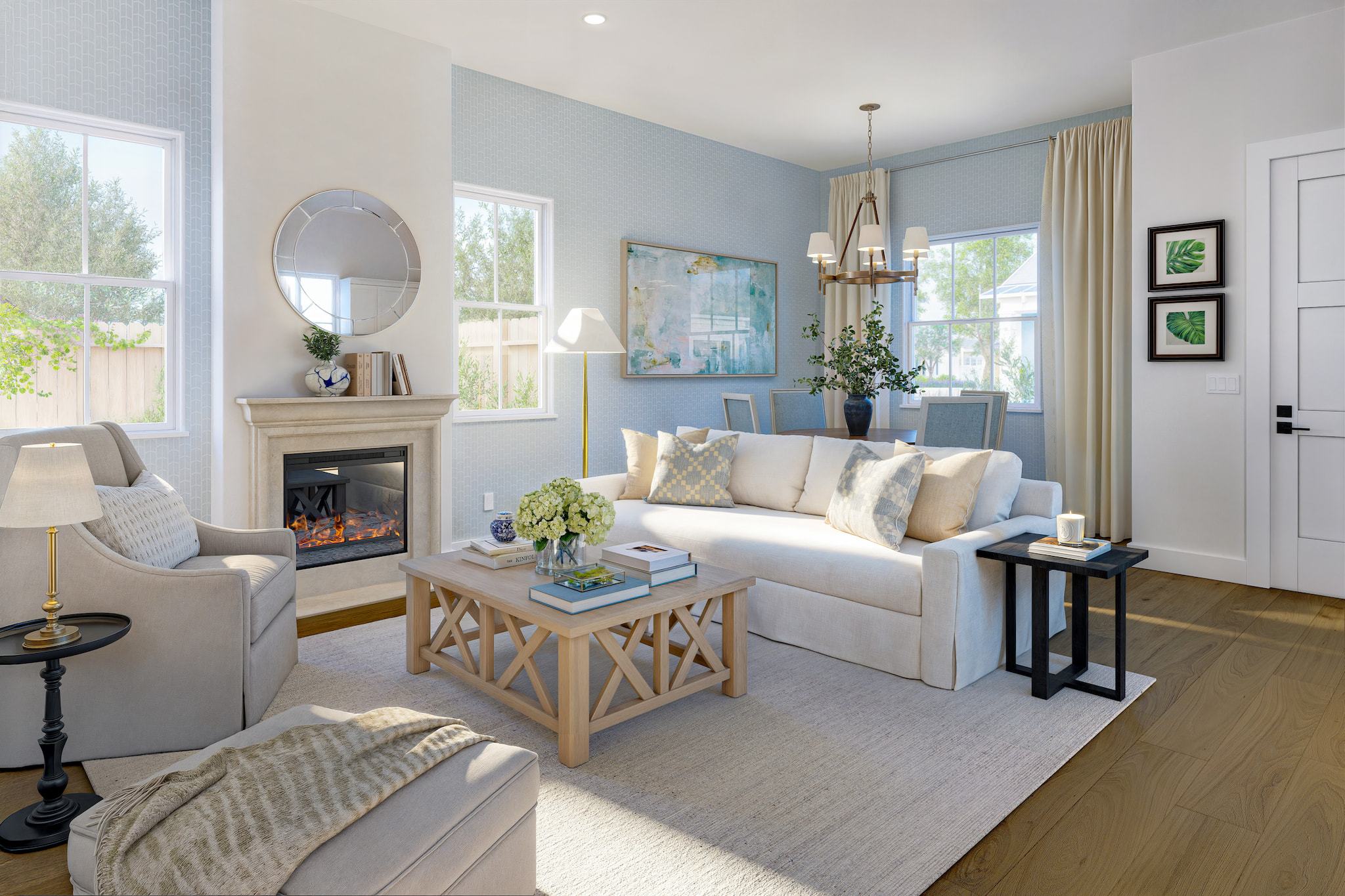 Open great room in The Monet Colonial Cottage with cozy fireplace, dining space, and natural light.