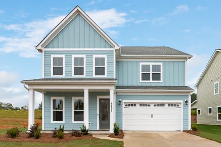 This Master-Up plan includes a main floor Guest Suite with a private bath, 10' ceilings down, and 9' ceilings up. The kitchen features quartz countertops, a large island with a farmhouse sink, and opens to the living room with adjacent outdoor patio.
