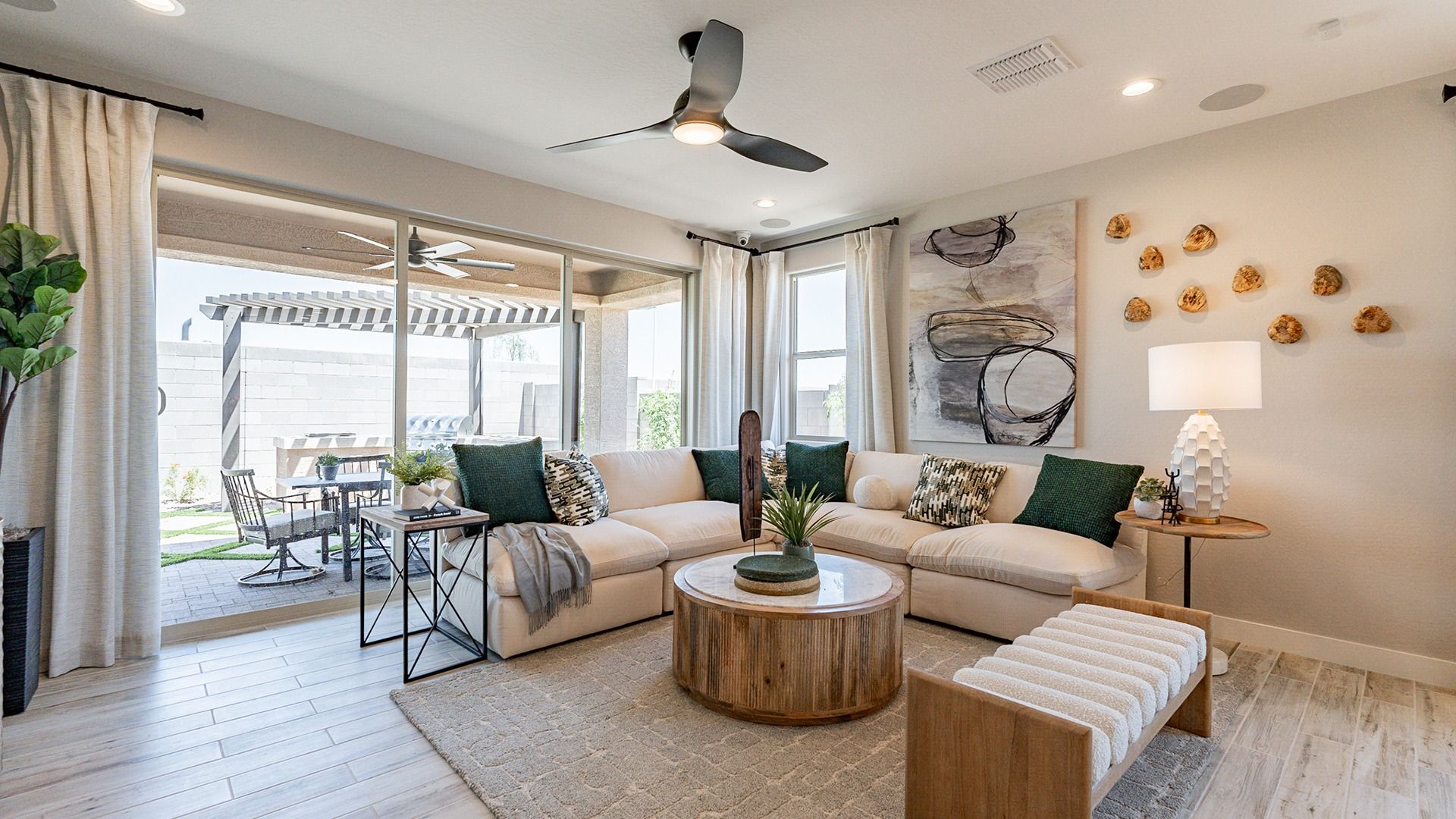 Luxurious living room in Sienna Park boasts a chic sectional, wood accents, and expansive patio access.
