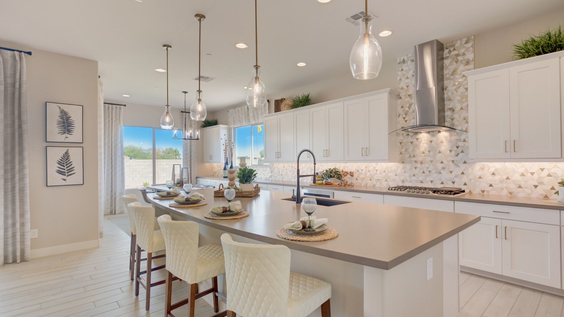 Exquisite kitchen features sleek island, modern pendant lights, and chic geometric backsplash, Palazzo community, Arroyo Seco.