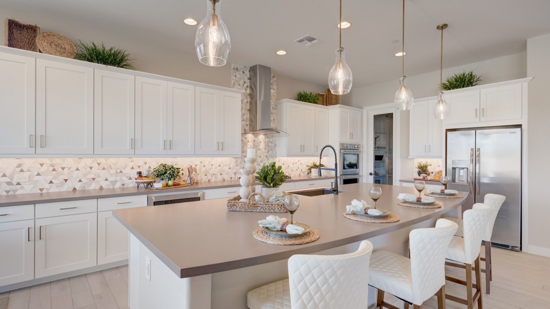 Experience sophistication with quartz countertops and geometric tile backsplash in Arroyo Seco's Palazzo community.