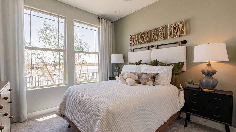 Spacious bedroom features expansive windows and refined decor, offering serene views in Sienna Park.