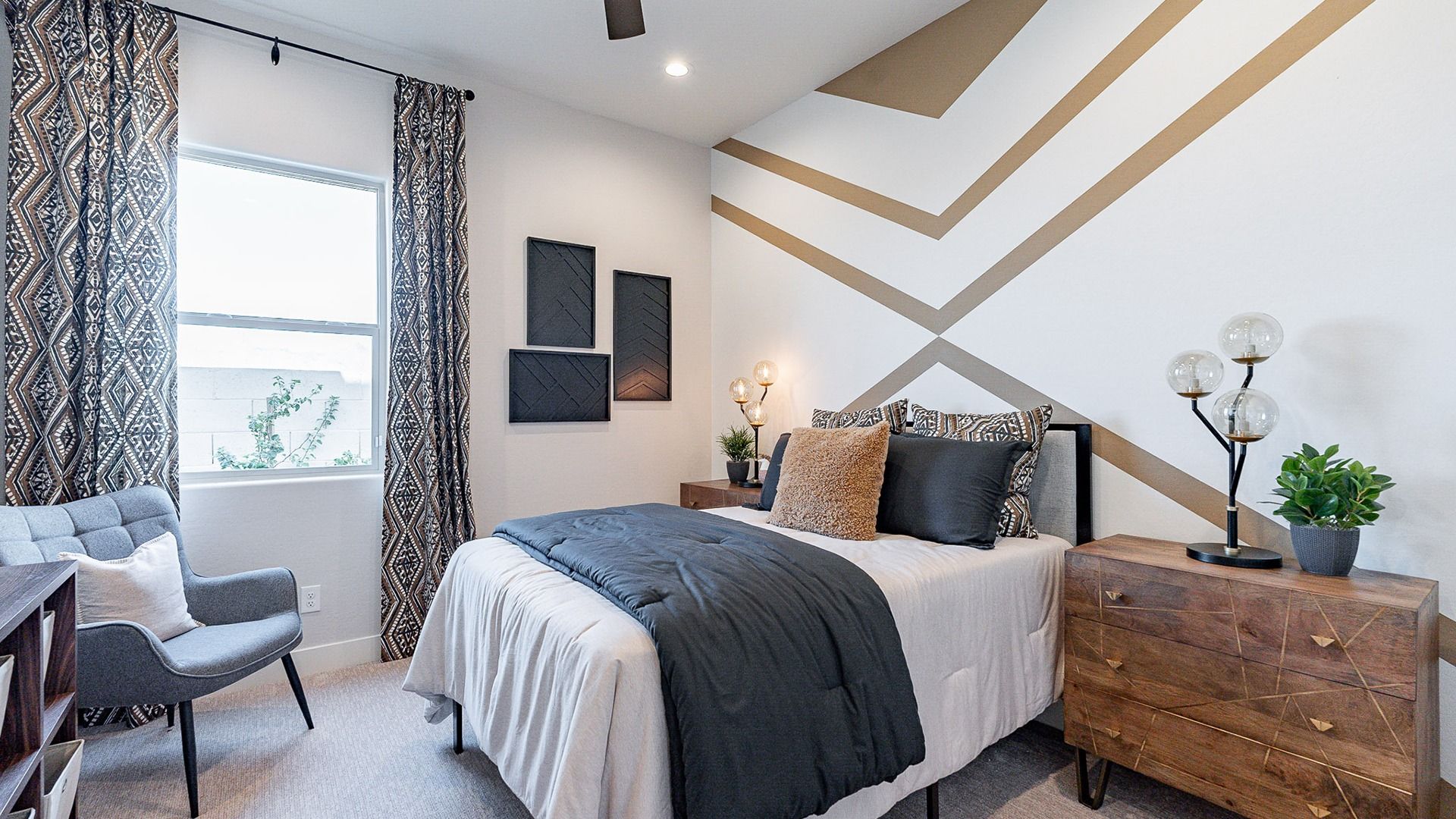 Experience luxury with this bedroom's geometric accent wall and chic furnishings in Windrose community.