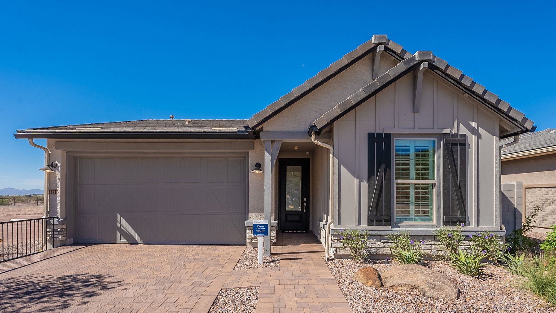 Elegant stone accents and refined paver driveway elevate this Arizona residence at The Villas at Mystic.