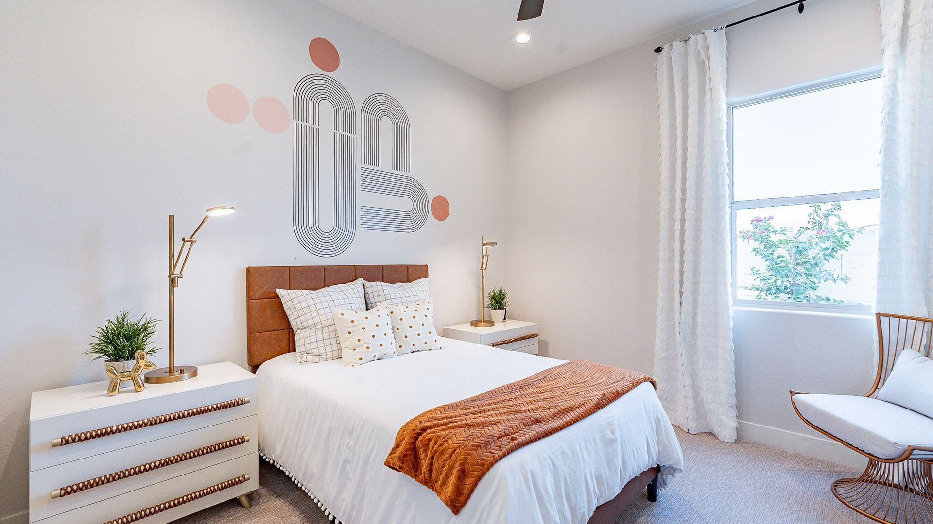 Modern bedroom in Windrose features unique geometric wall art, plush textiles, and sleek lighting.