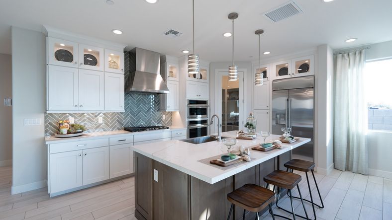 Luxurious Mystic kitchen boasts a marble-topped island, herringbone tile, and custom cabinetry.