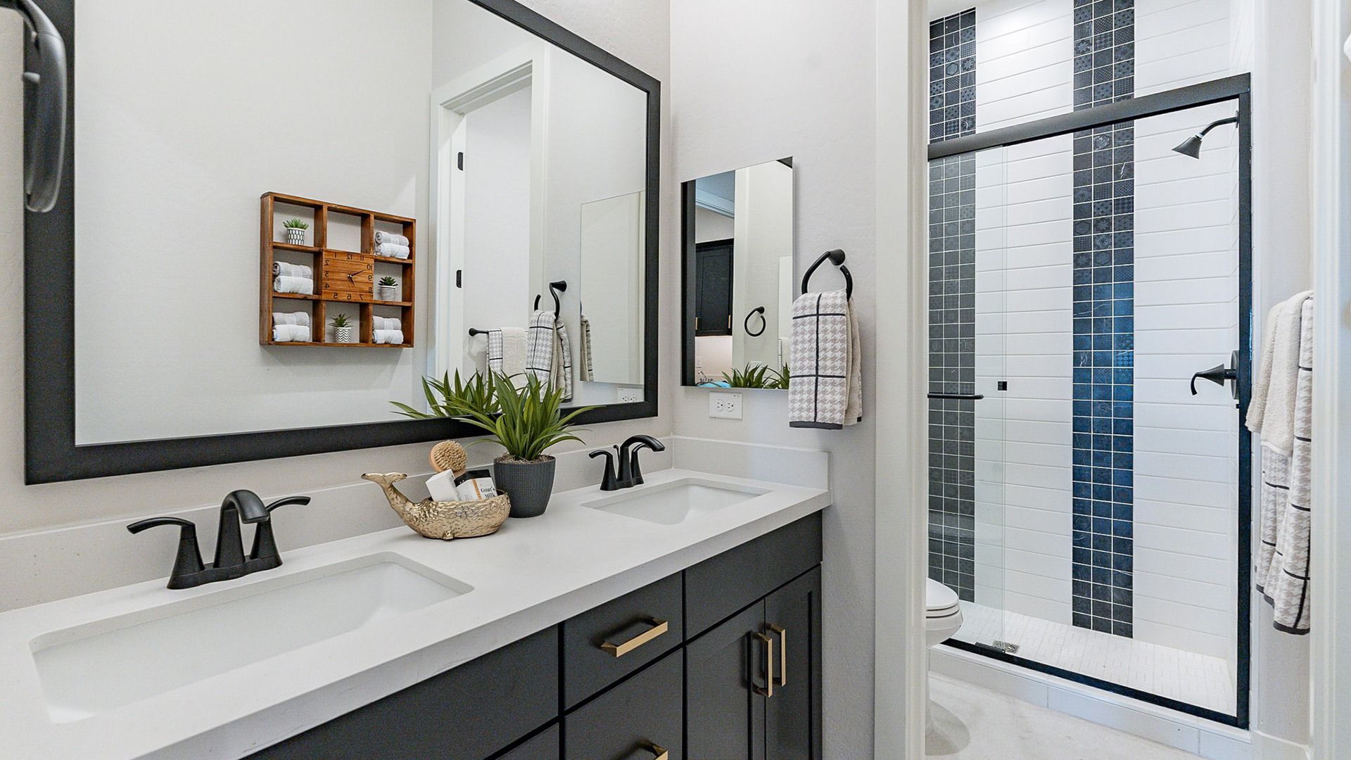 Luxurious Windrose bathroom features sleek black cabinetry and elegant glass shower.