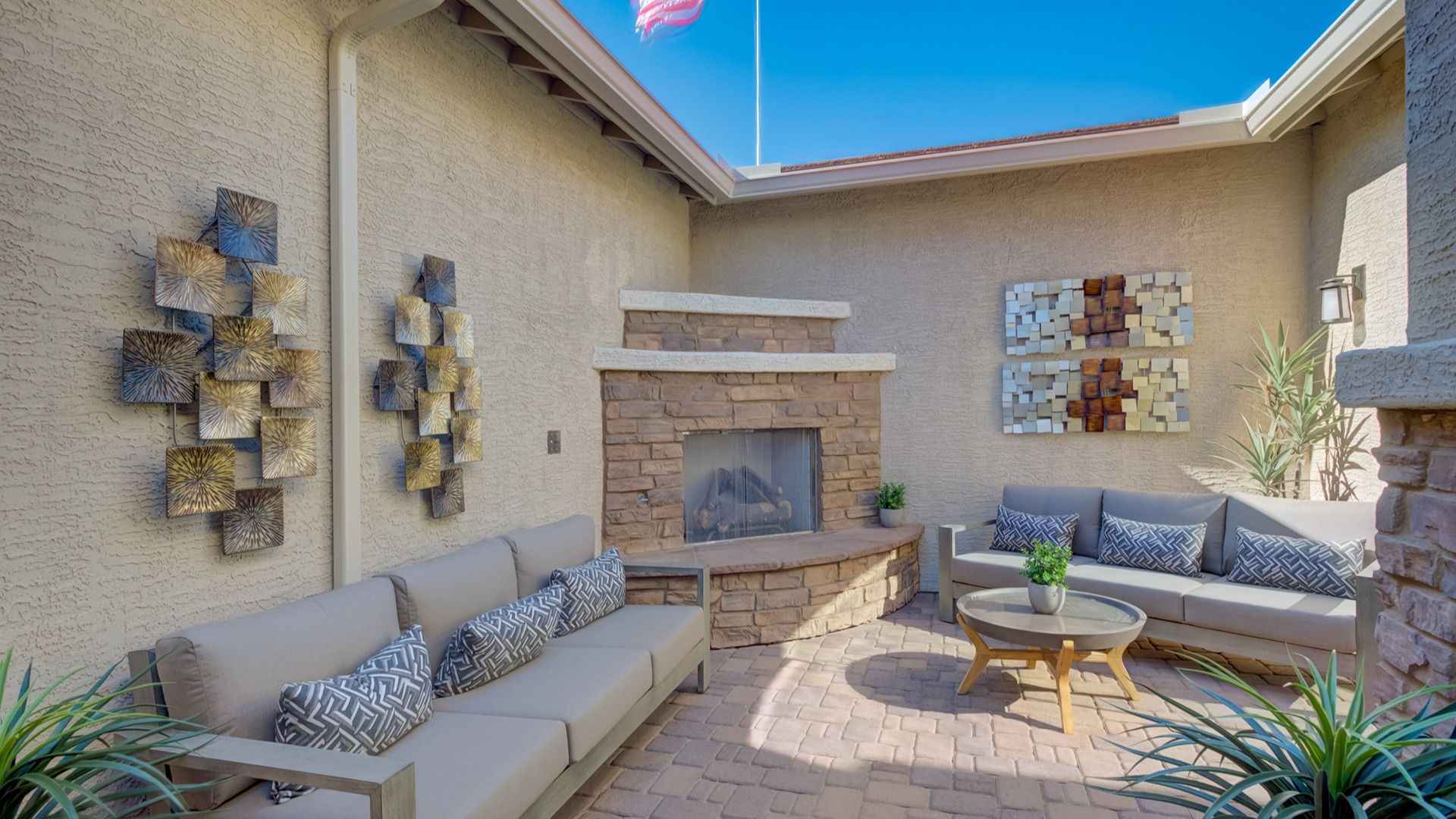 Experience refined outdoor living with a stone fireplace, exquisite metal art, and sophisticated seating, Arroyo Seco.