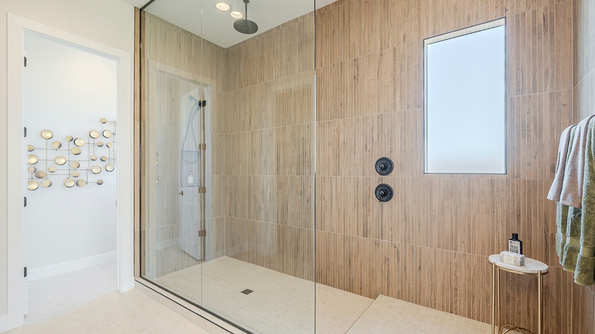 Immerse in luxury with an expansive glass-enclosed shower, premium wood tile, and modern fixtures. Hacienda at Estrella.