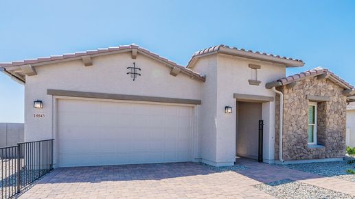 Exquisite stone facade and elegant tile roofing highlight this Windrose residence's timeless charm.