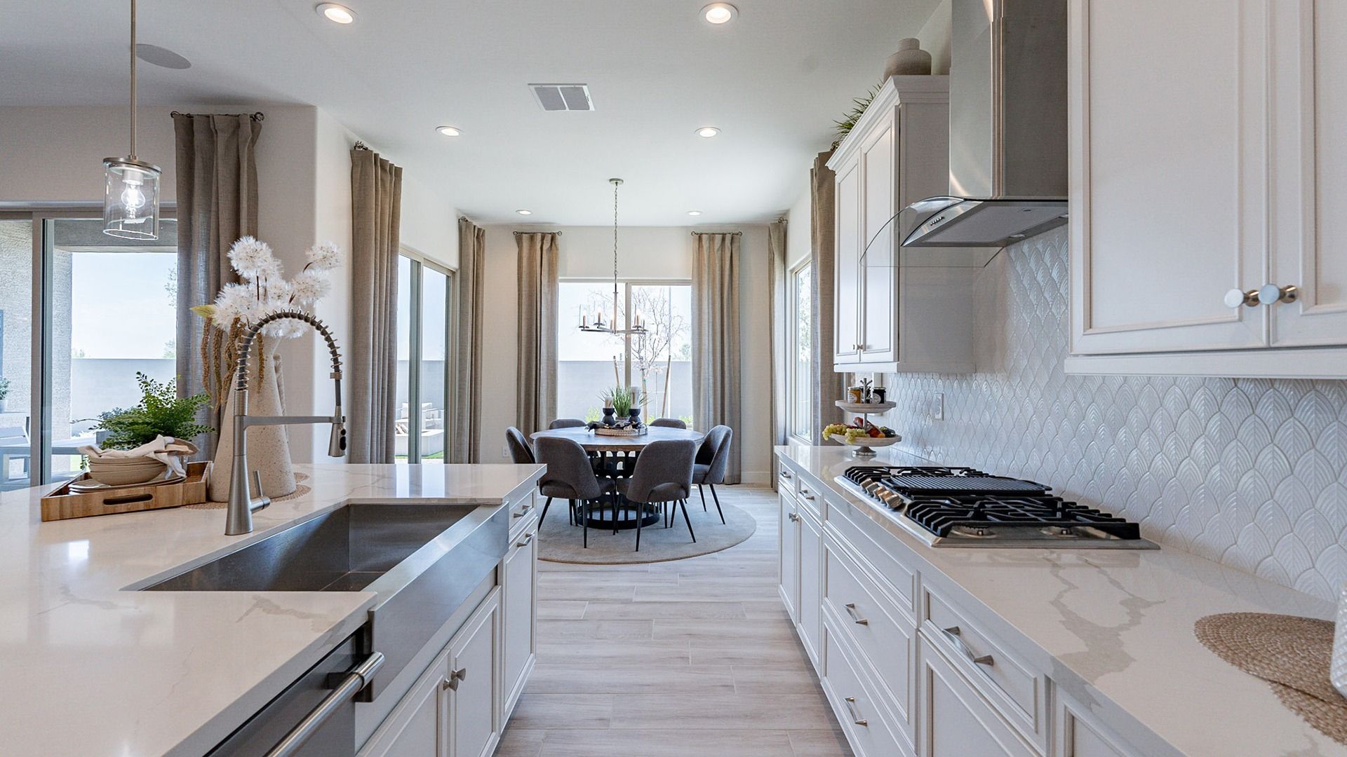 Elegant white cabinetry and high-end steel fixtures in Windrose's luxurious kitchen design.