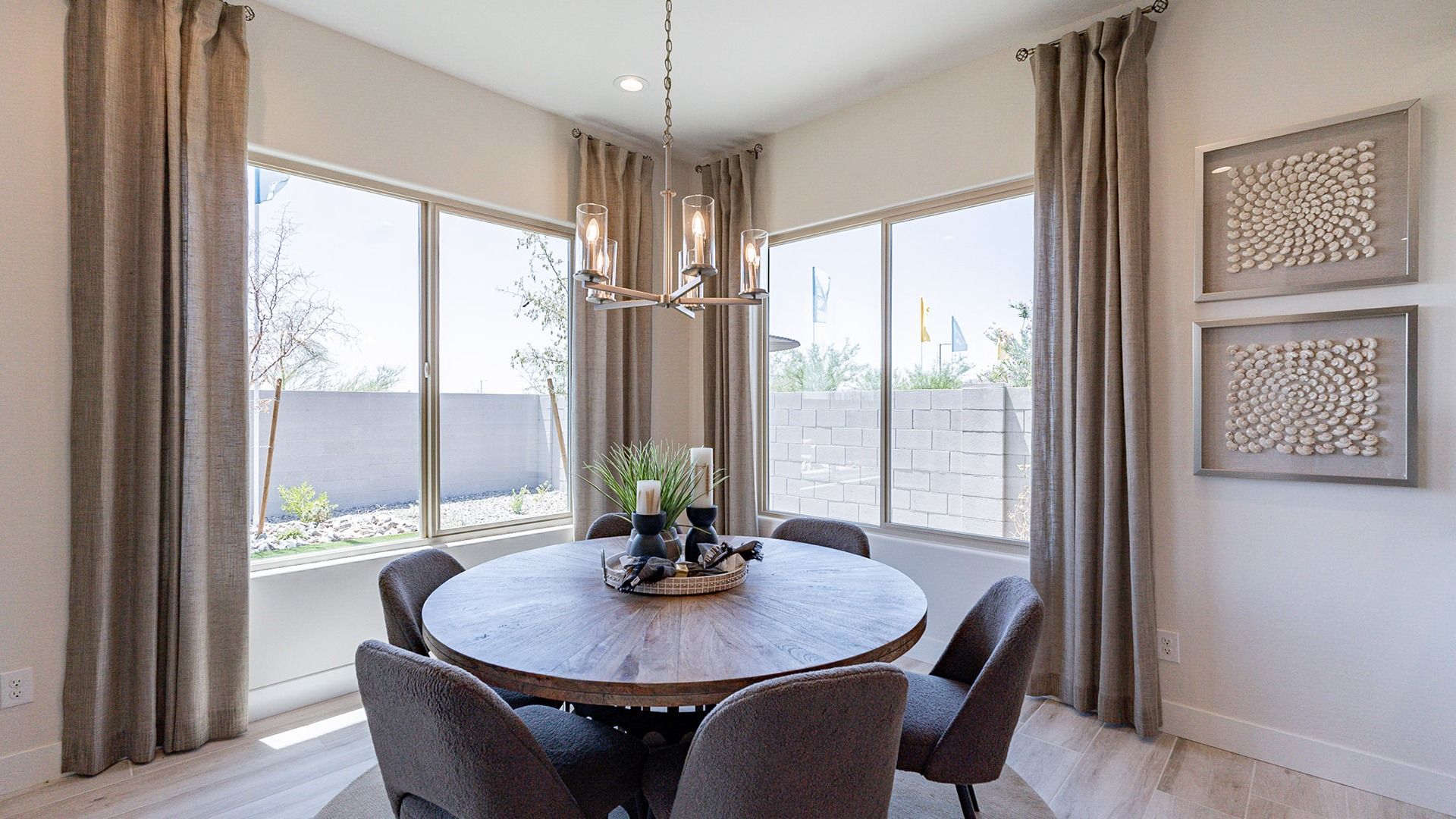 Discover refined elegance with a modern chandelier and wood table in Windrose's luxurious dining space.