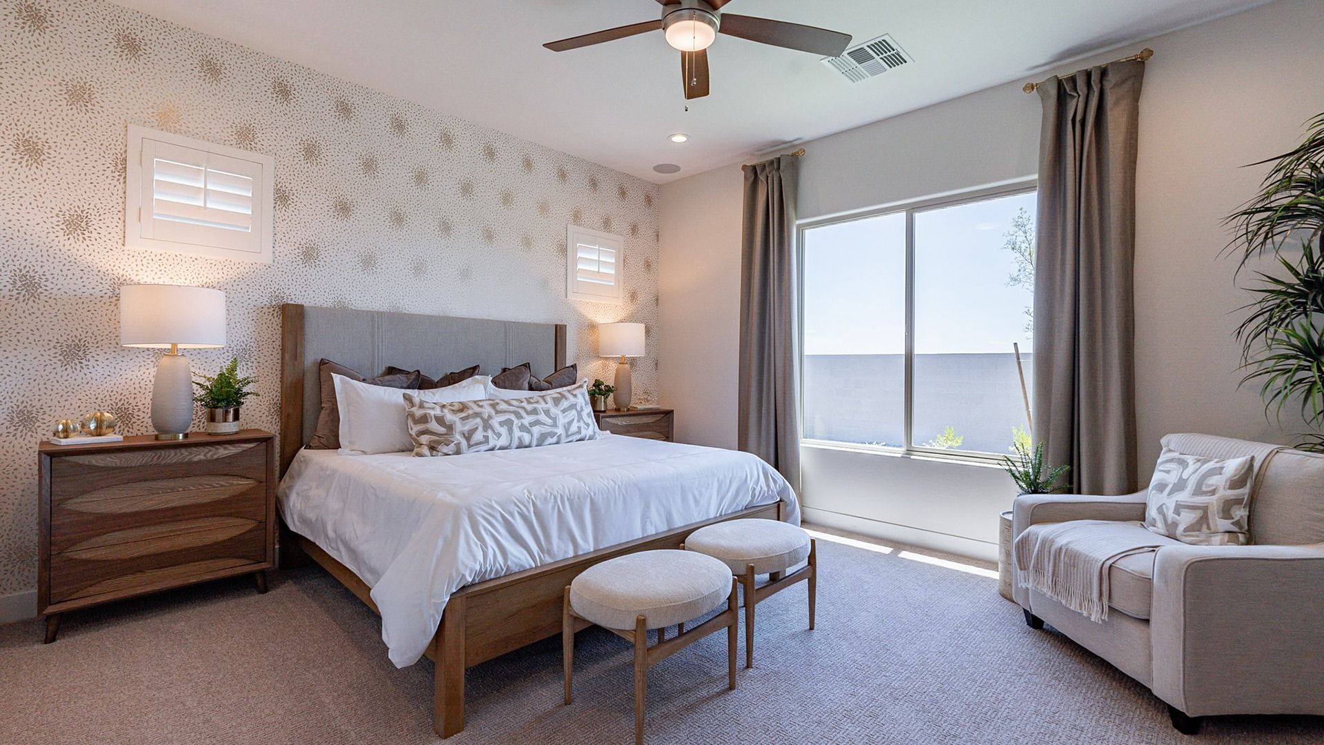Sophisticated bedroom features chic wood furnishings, plush textiles, and expansive windows in Windrose.