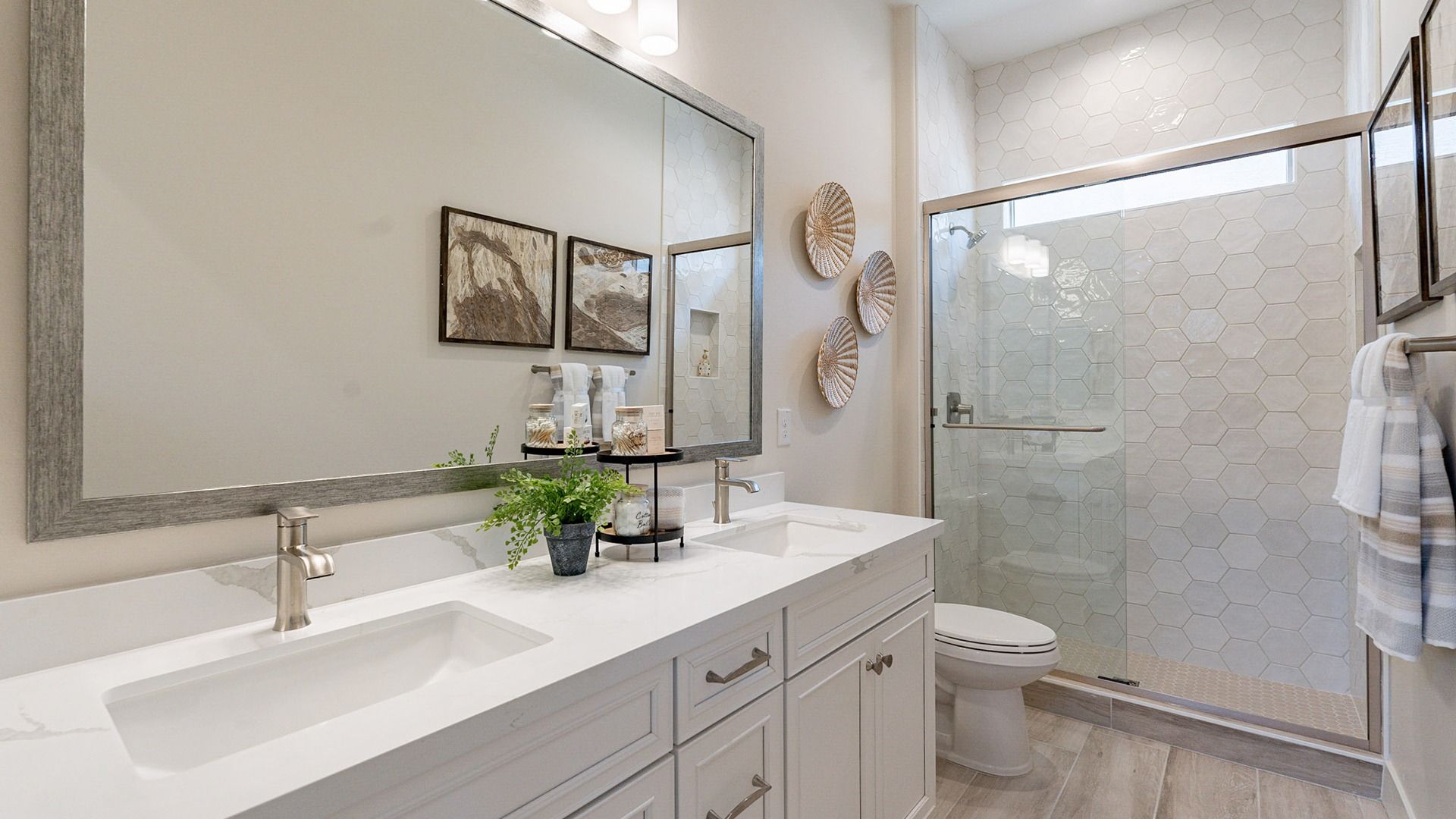 This Windrose bathroom features elegant hexagonal shower tiles, dual sinks, and a spacious vanity.