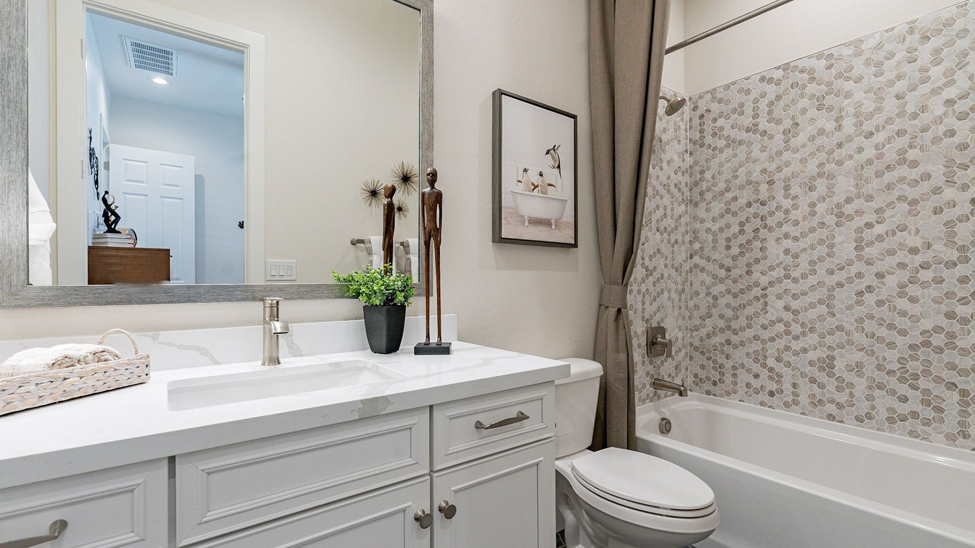 Elegant hexagonal tiles and sleek fixtures define this Windrose bathroom's modern luxury.