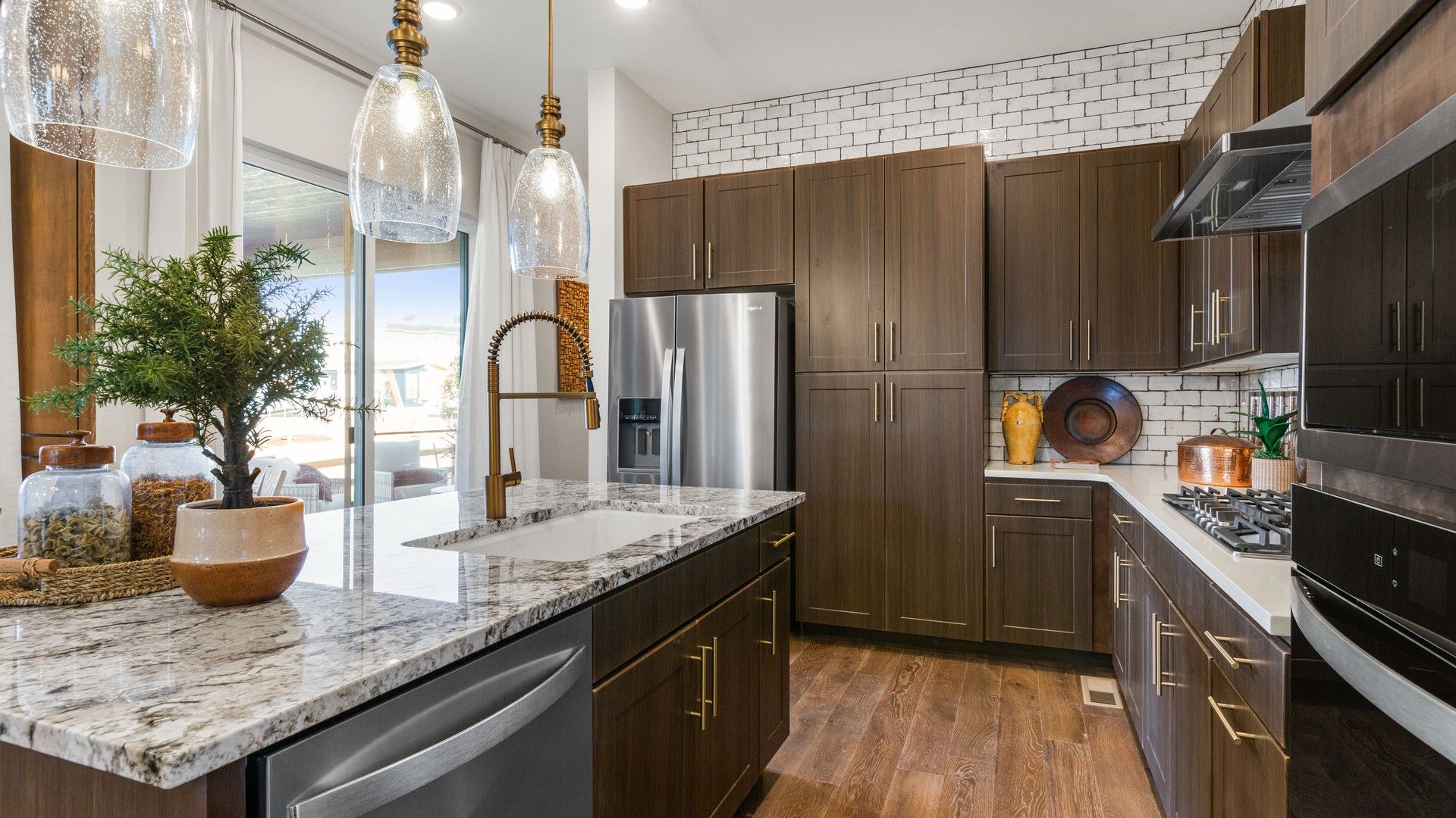 Experience luxury with granite countertops and rich wood cabinetry in Dillon Pointe's refined kitchen.