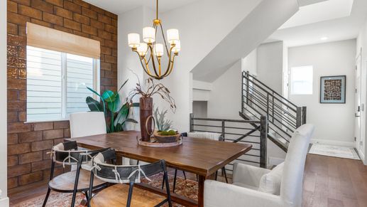 Refined hardwood flooring and brick feature wall highlight the sophisticated Dillon Pointe dining space.
