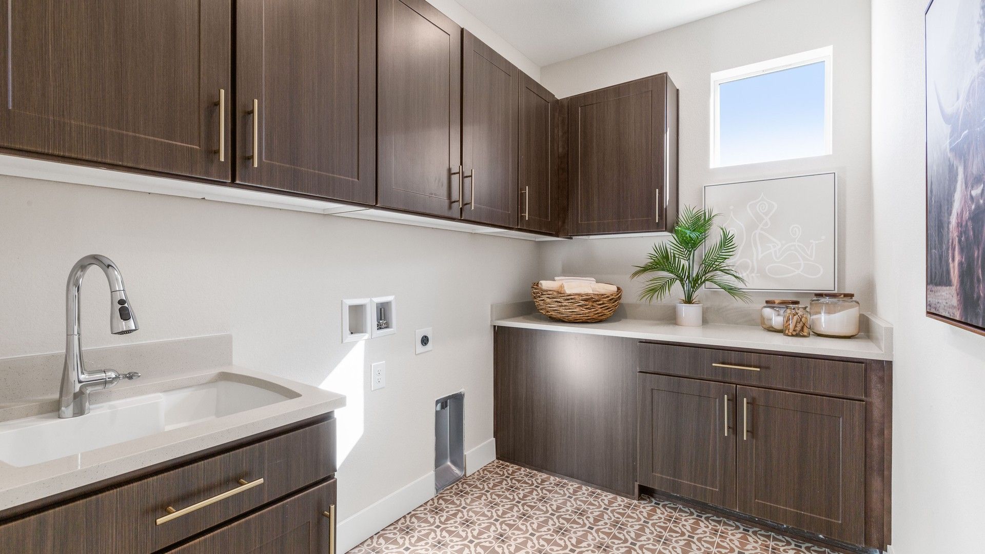 Dillon Pointe laundry features luxurious dark wood cabinetry and artisanal tile flooring, epitomizing modern design.