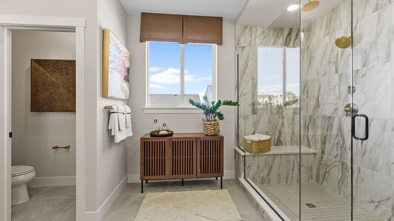 Indulge in this Dillon Pointe retreat with elegant marble shower, sleek wood finishes, and panoramic views.