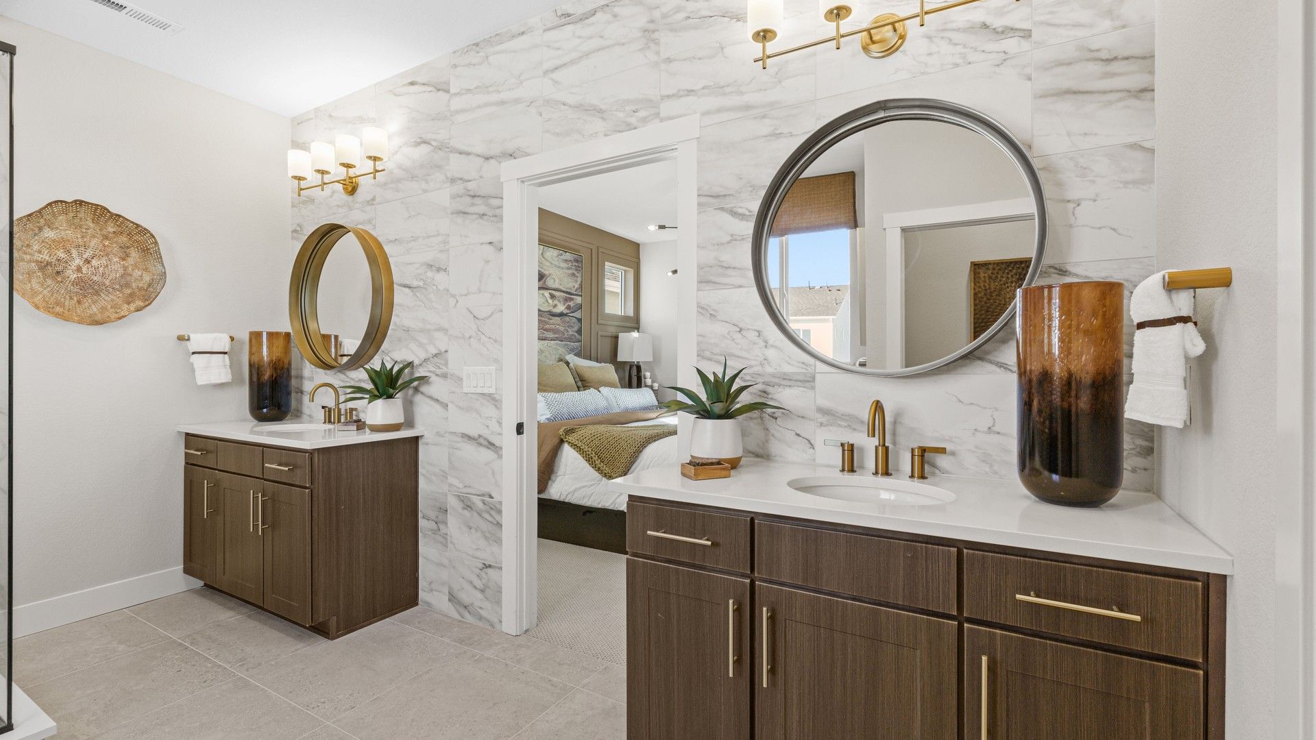 Dillon Pointe offers a refined bathroom featuring marble walls, dual vanities, and gold accents for a sophisticated look