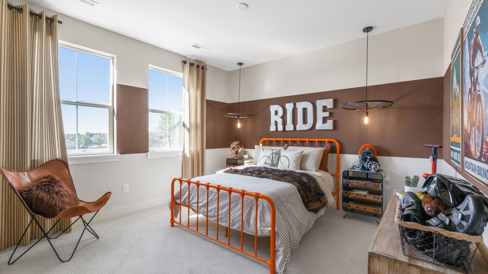 Elegant Dillon Pointe bedroom showcases unique orange metal bed and cyclist-themed decor.