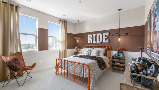 Elegant Dillon Pointe bedroom showcases unique orange metal bed and cyclist-themed decor.