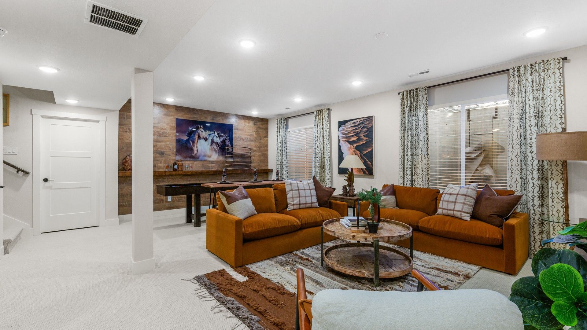 Sophisticated Dillon Pointe room features luxe orange seating, rich wood finishes, and curated art.