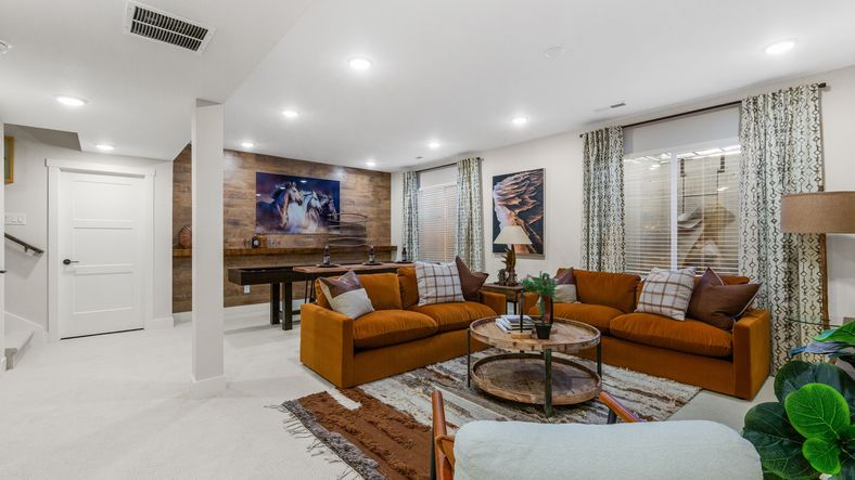 Sophisticated Dillon Pointe room features luxe orange seating, rich wood finishes, and curated art.