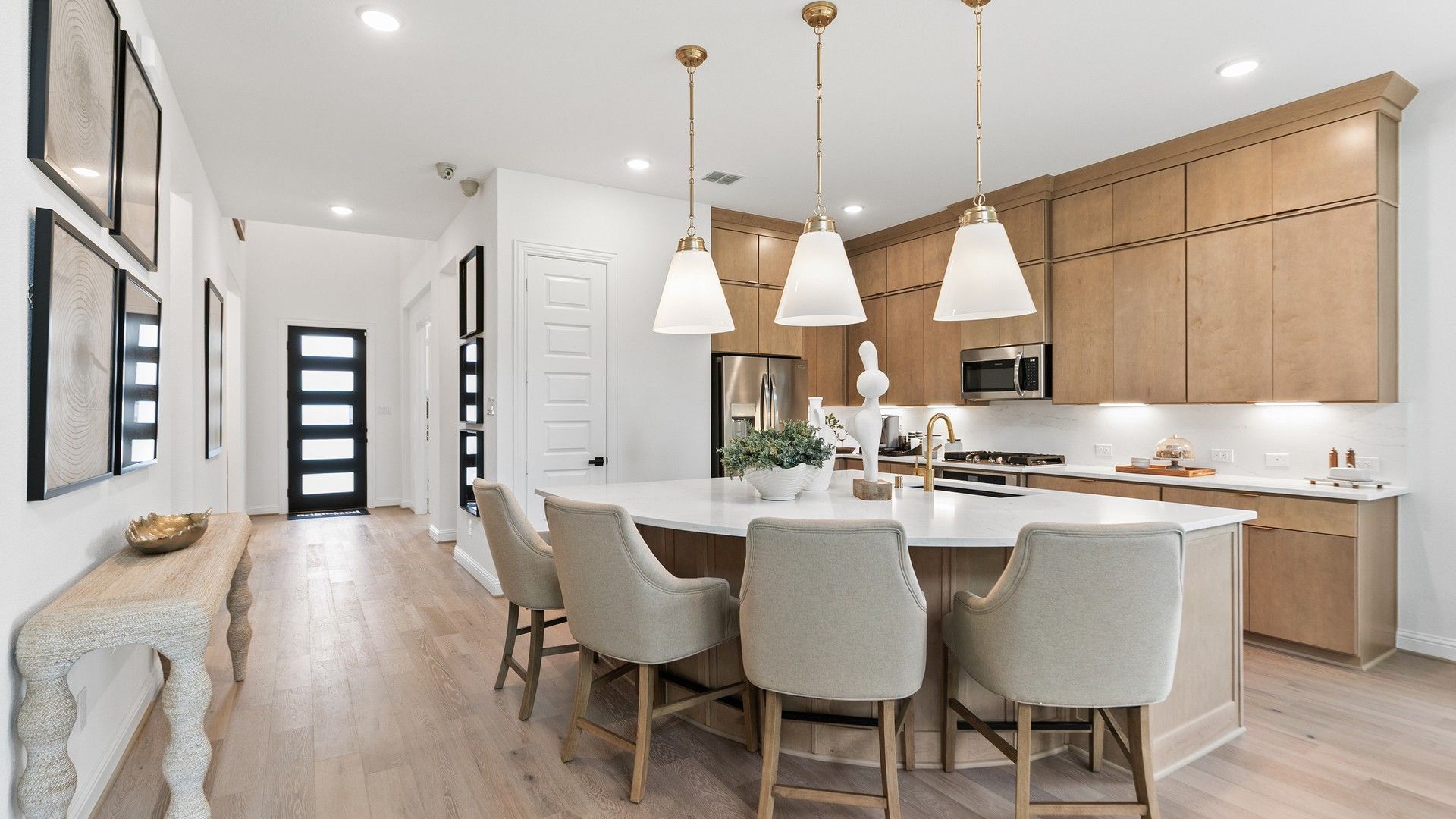 Exquisite quartz island, sleek light wood cabinetry, and elegant lighting in Katy Lakes.