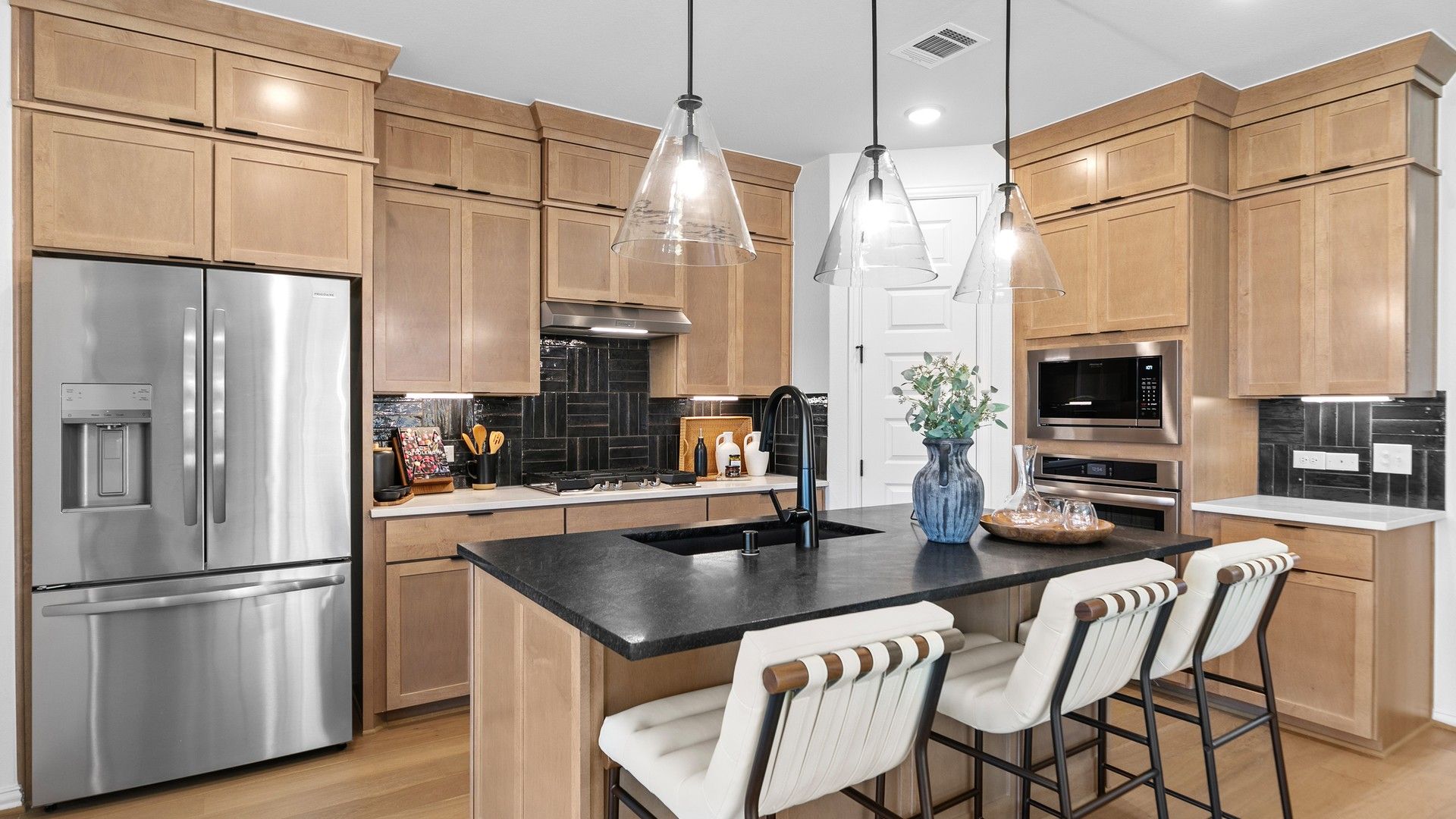 Discover the allure of custom wooden cabinetry and sleek black countertops in River Ranch's modern kitchen.