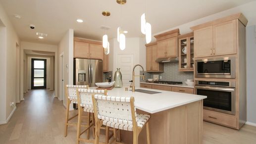 Luxurious Ellis Cove kitchen features sleek wood cabinetry and elegant marble countertops.