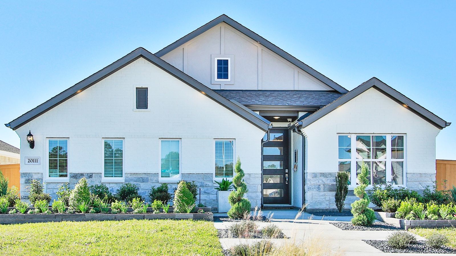 Elegant Cypress Green home features sleek stone accents and expansive windows, offering a refined living experience.