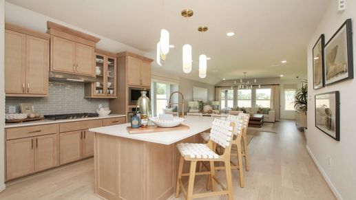 Experience elegance with light wood cabinets and chic pendant lights in Ellis Cove's modern kitchen.