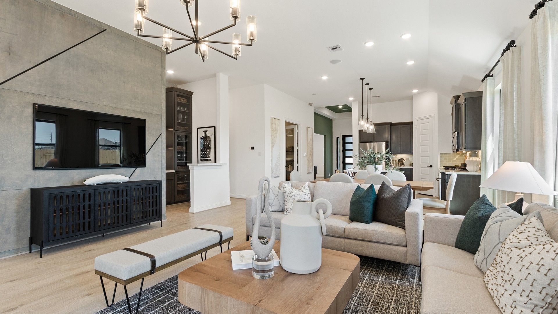 Experience luxury with sleek concrete media wall and designer lighting in Oakwood Estates' open-plan living space.