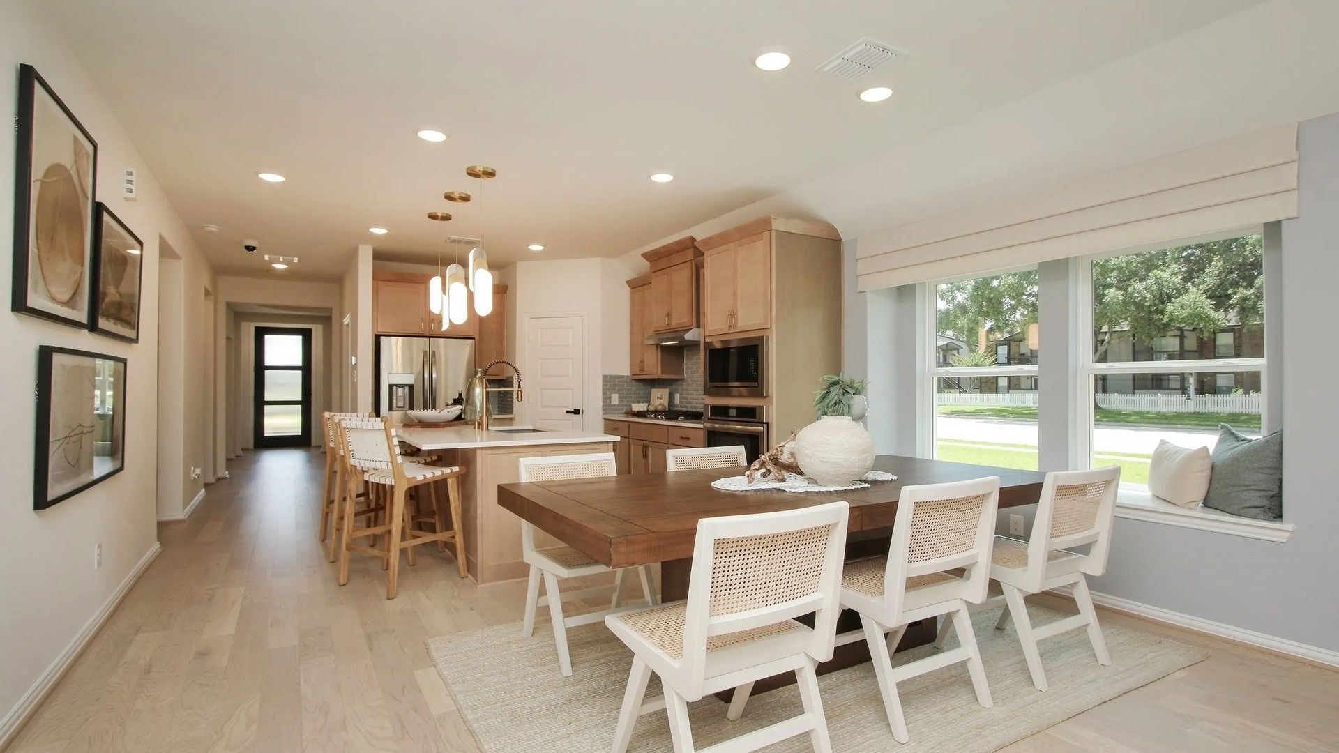Experience refined elegance with light wood floors and sleek lighting in Ellis Cove's modern kitchen-dining space.