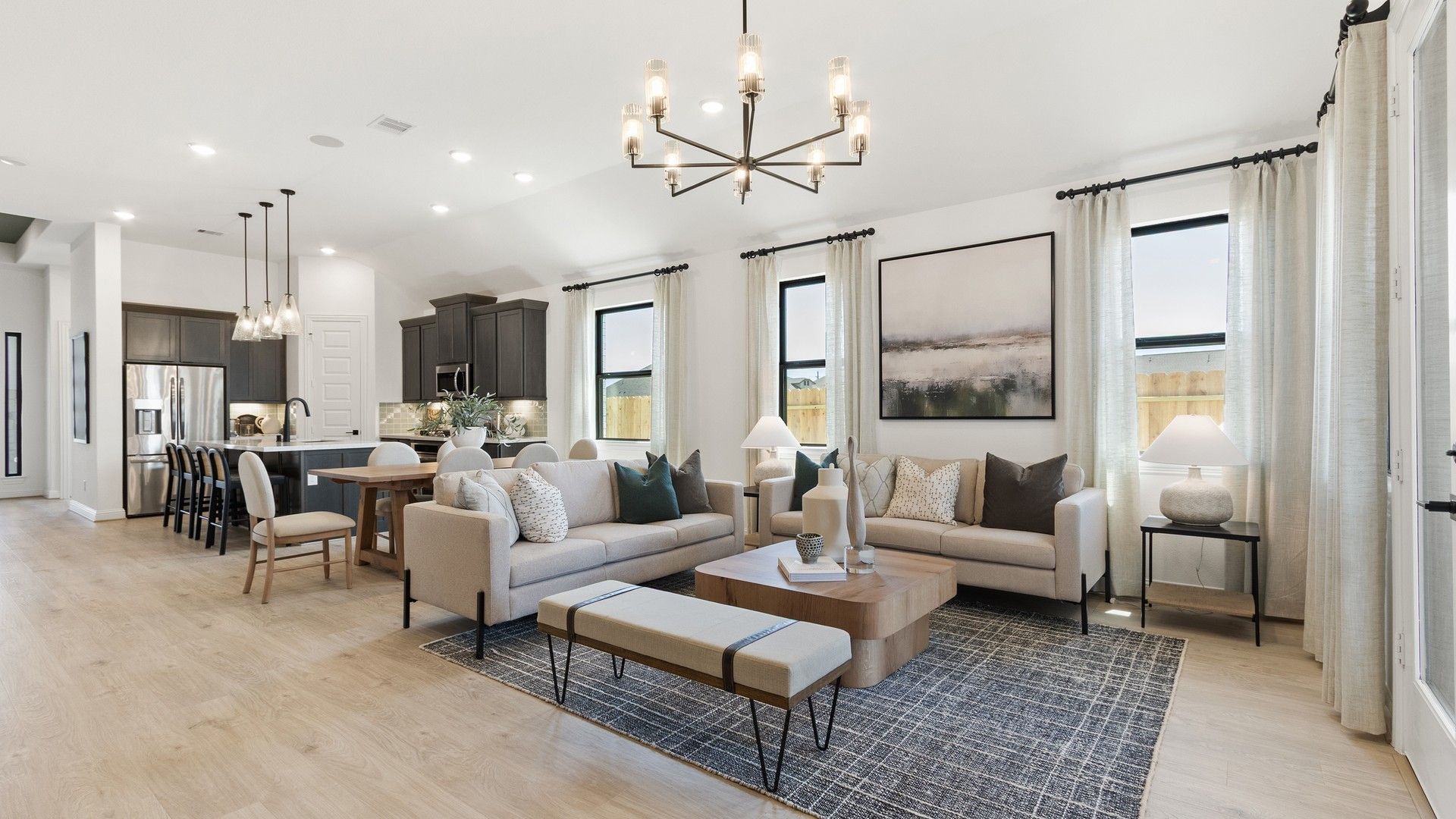 Luxurious open space with hardwood floors, sleek cabinetry, and chic chandelier in Oakwood Estates.