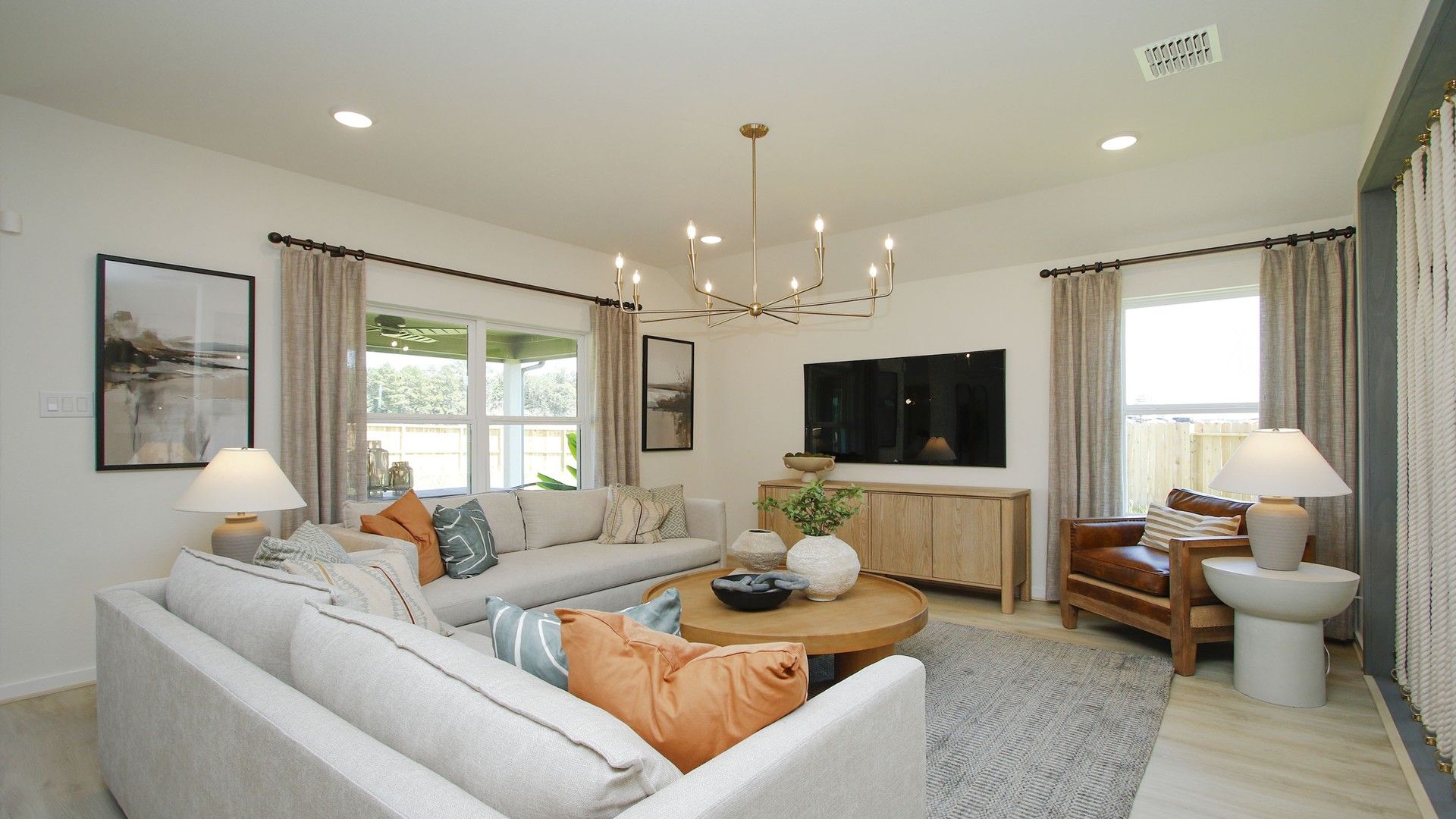 Luxurious Cielo living room features a striking chandelier and cozy seating, framing picturesque window views.