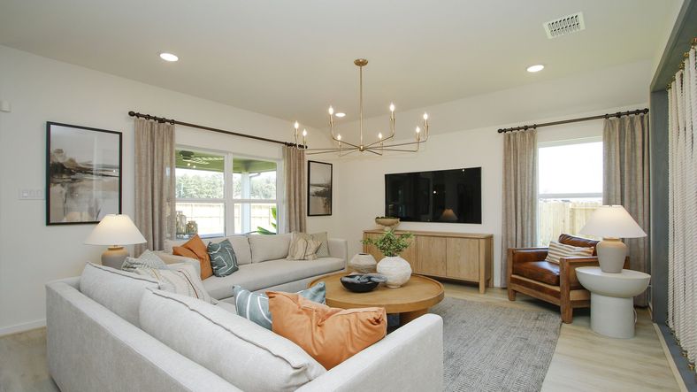 Luxurious Cielo living room features a striking chandelier and cozy seating, framing picturesque window views.