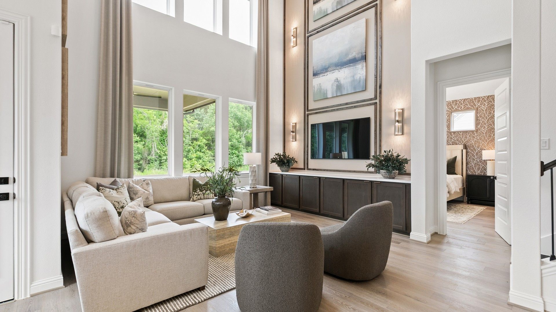 High ceilings and expansive windows illuminate this sophisticated living space in Katy Lakes, offering serene elegance.
