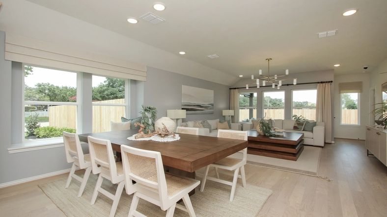 Spacious open-concept living room with custom wood dining table and panoramic windows. Ellis Cove elegance.